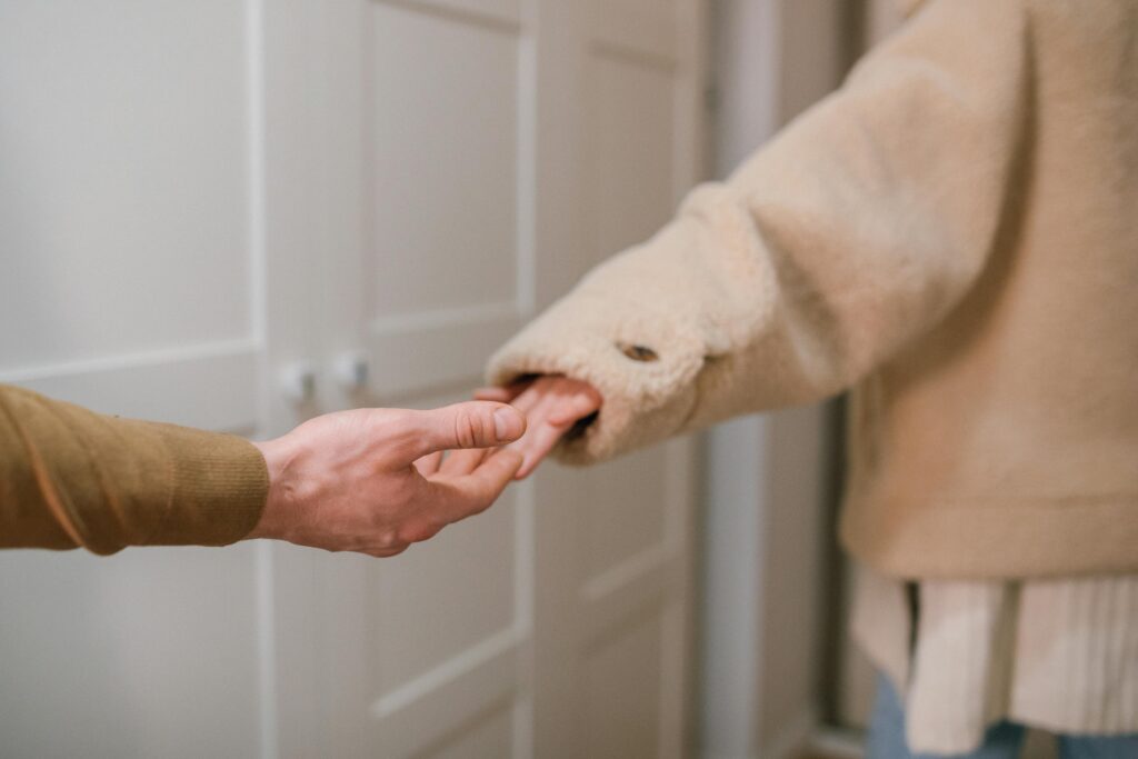 Two people's hands parting as the one leaves.