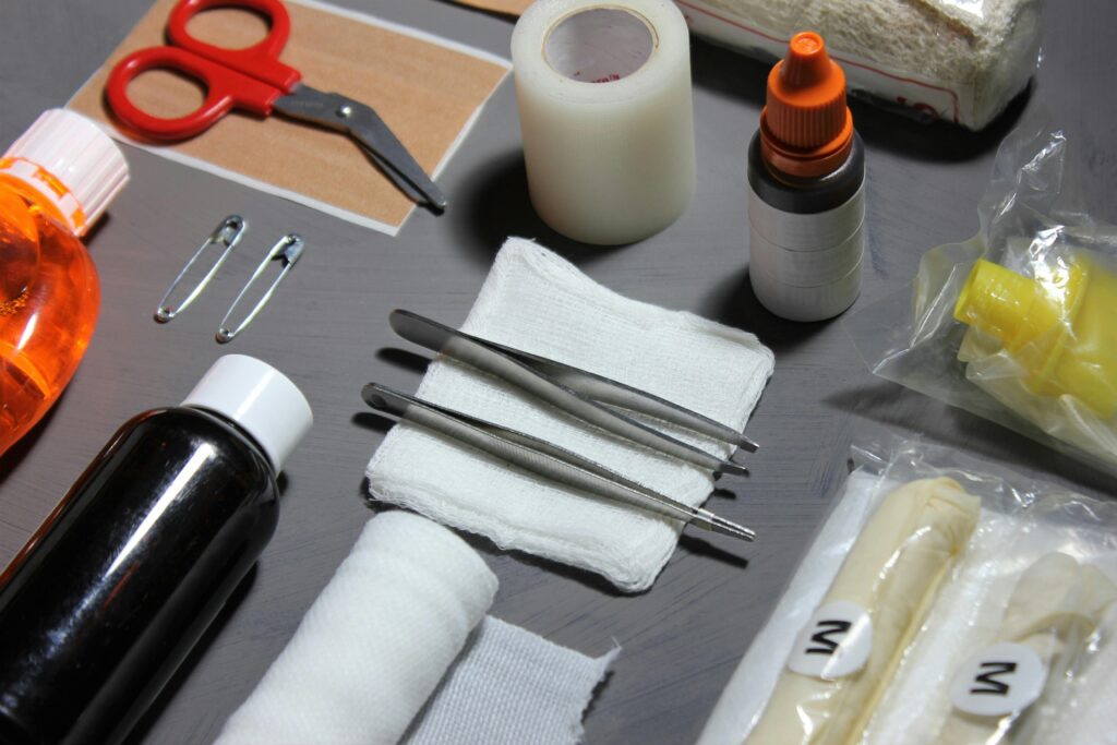 First aid supplies for splinter removal including tweezers, scissors, gauze, antiseptic, and bandages.