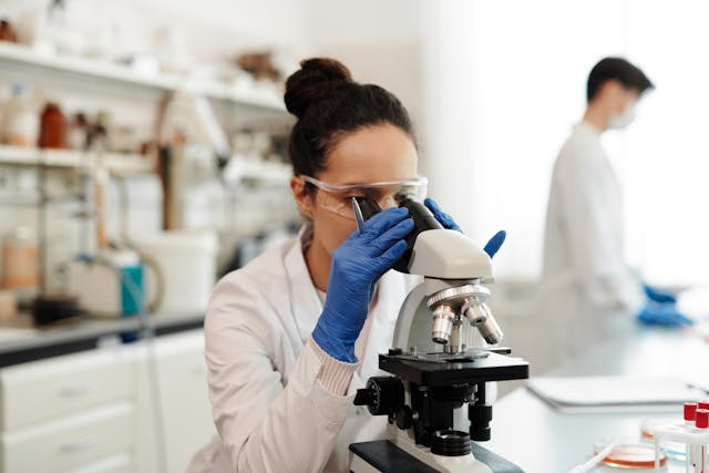 researcher lookingthrough microscope