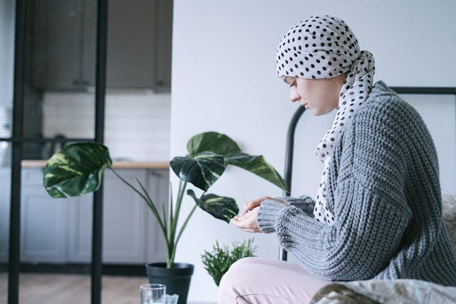 A cancer patient sitting on the edge of her bad
