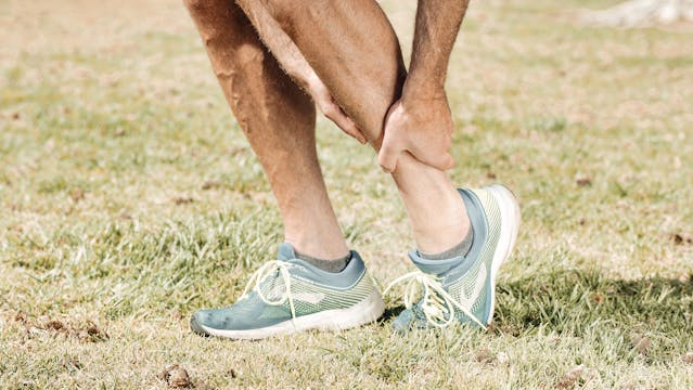 man holding ankle