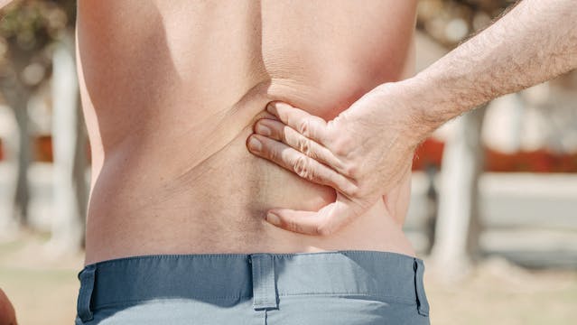 man holding his back
