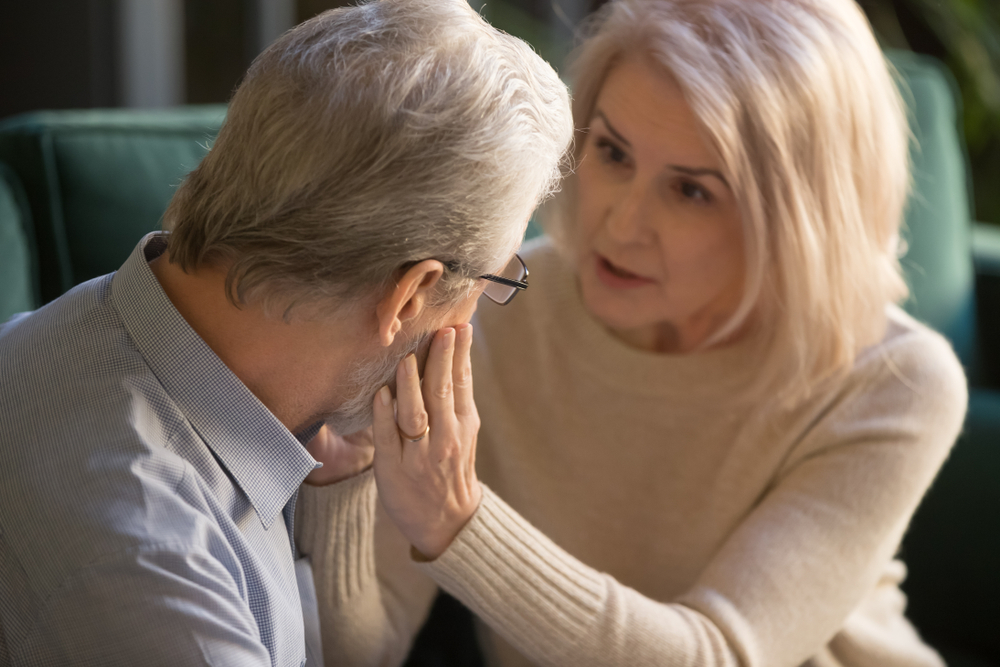 Loving kind mature wife comforting gently touching face of elder man helping with health problem, understanding middle aged spouse talking consoling older husband give hope empathy support concept