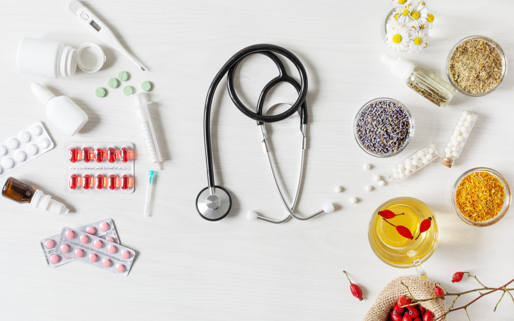 Alternative medicine VS traditional medicine concept. Variety treatments top view on white wooden background.