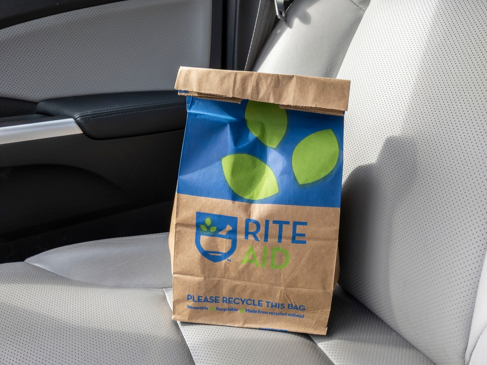Seattle, WA USA - circa March 2022: Angled view of a brown paper Rite Aid bag sitting inside a car, with a prescription inside.