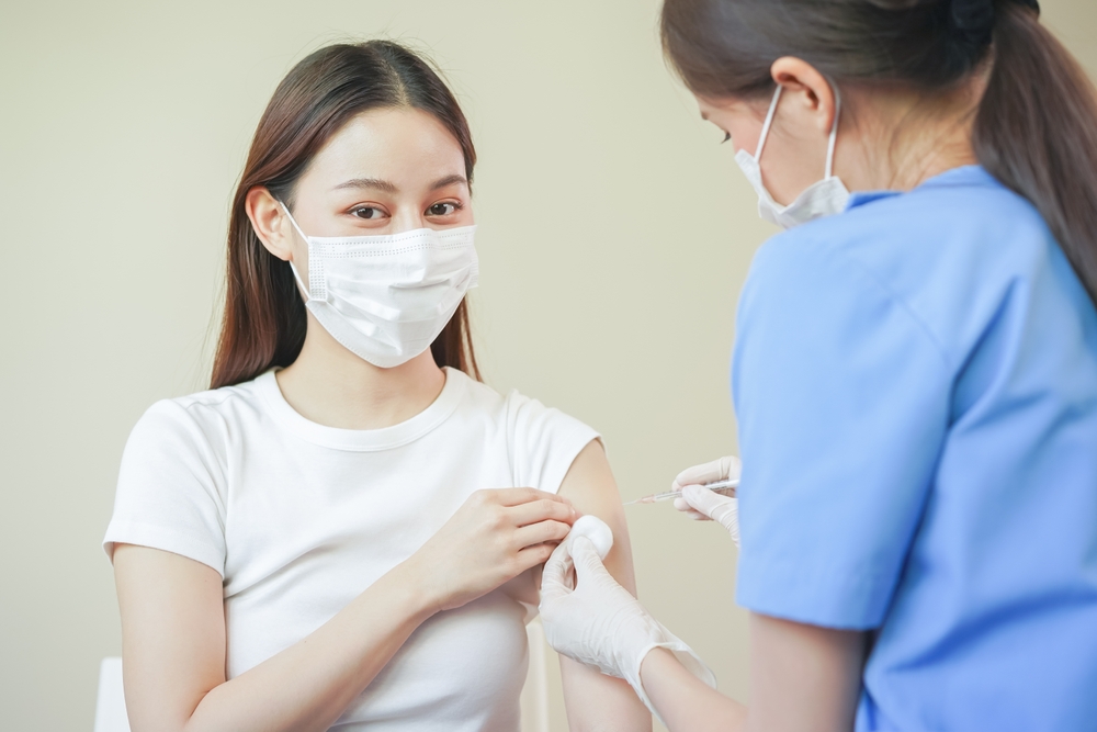 Covid-19,coronavirus hand of young woman nurse,doctor giving syringe vaccine, inject shot to asian arm's patient. Vaccination, immunization or disease prevention against flu or virus pandemic concept.