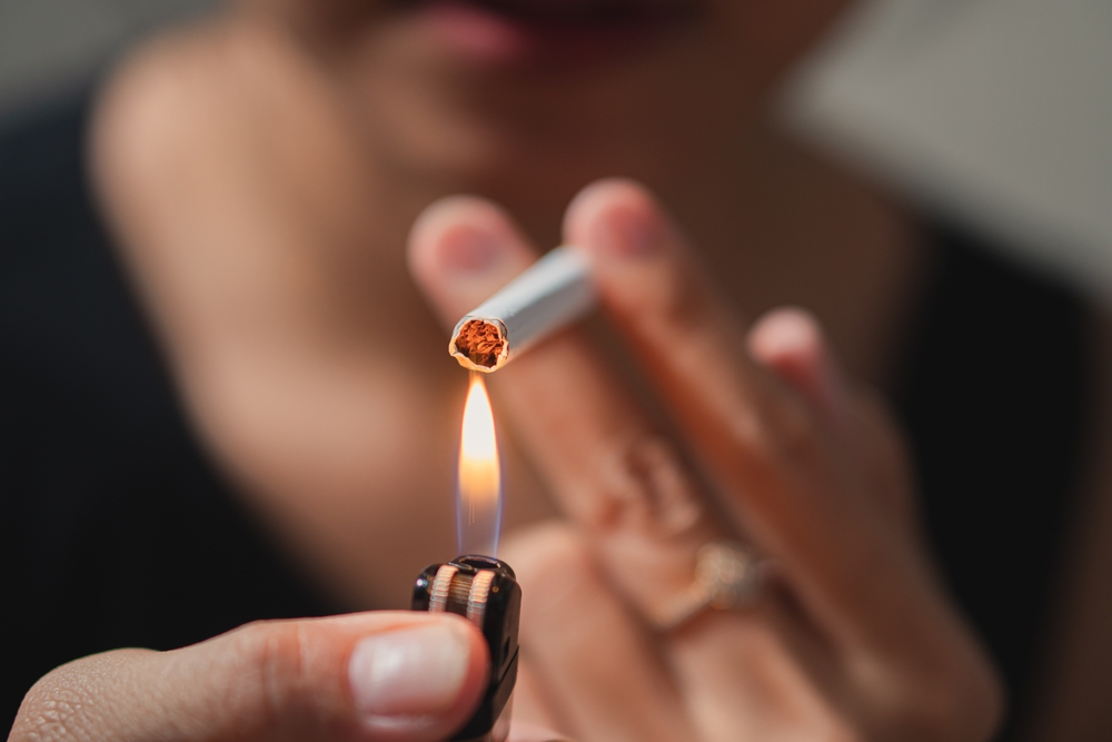 Smoker lighting a cigarette with lighter
