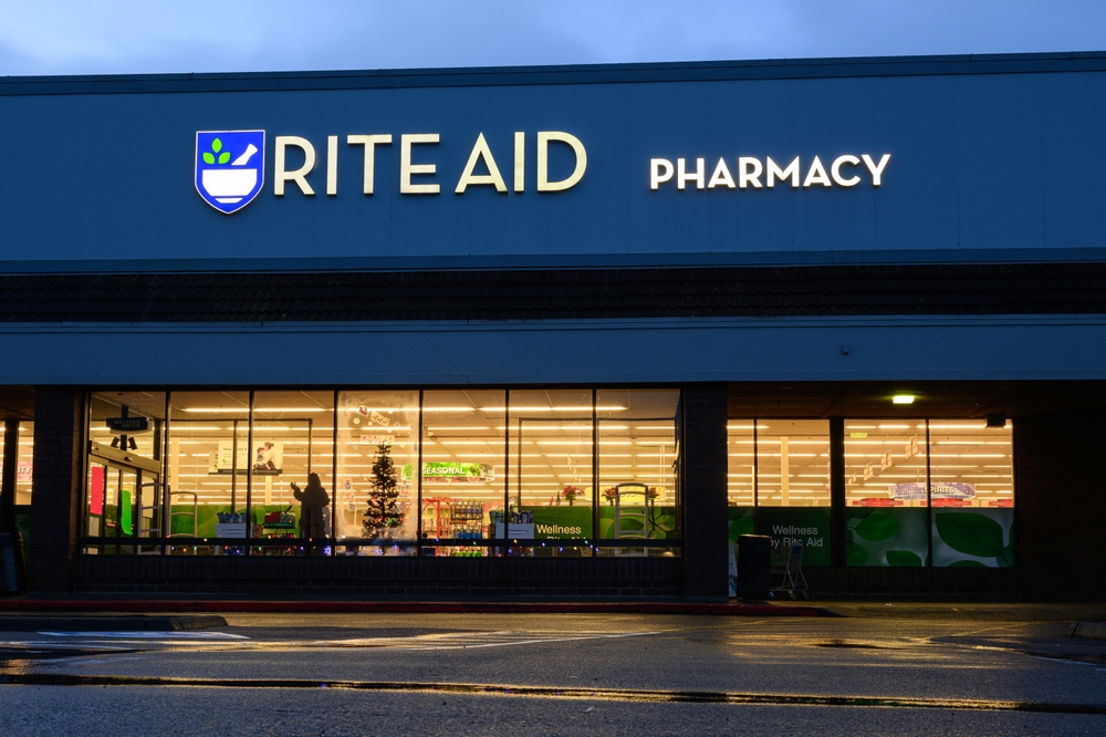 Issaquah, WA, USA - December 10, 2023; Night view of Rite Aid Pharmacy with lights in store window and reflection in wet asphalt