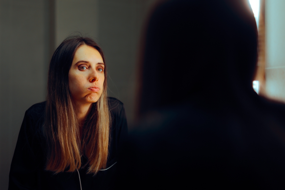 
Stressed Woman Looking in the Mirror Feeling Anxious. Happy millennial girl insecure and with low self esteem
