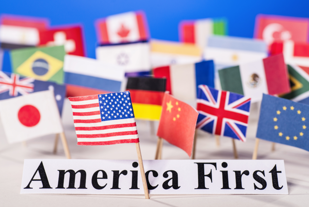 American flag is in front of the slogan America First and many flags of other countries.