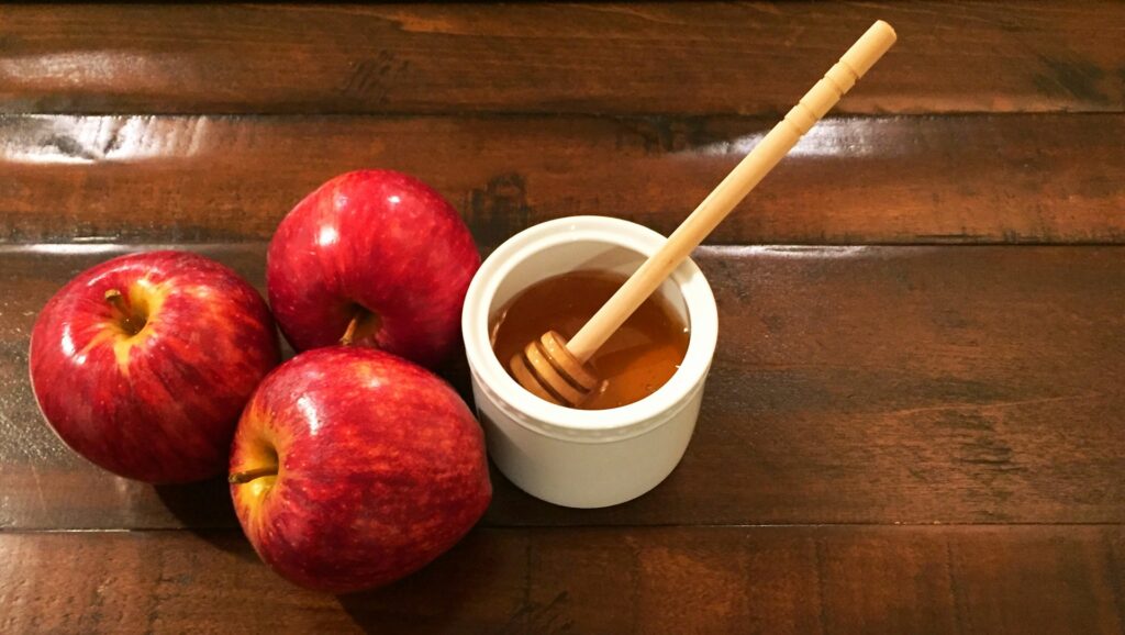 a bowl of soup next to some apples