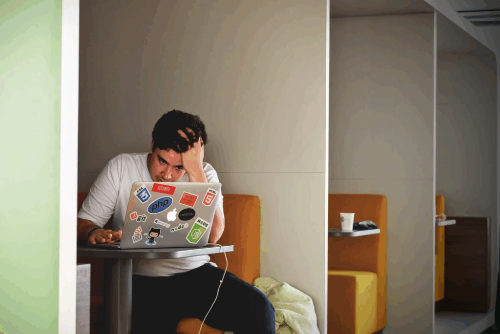 man on laptop sitting in booth