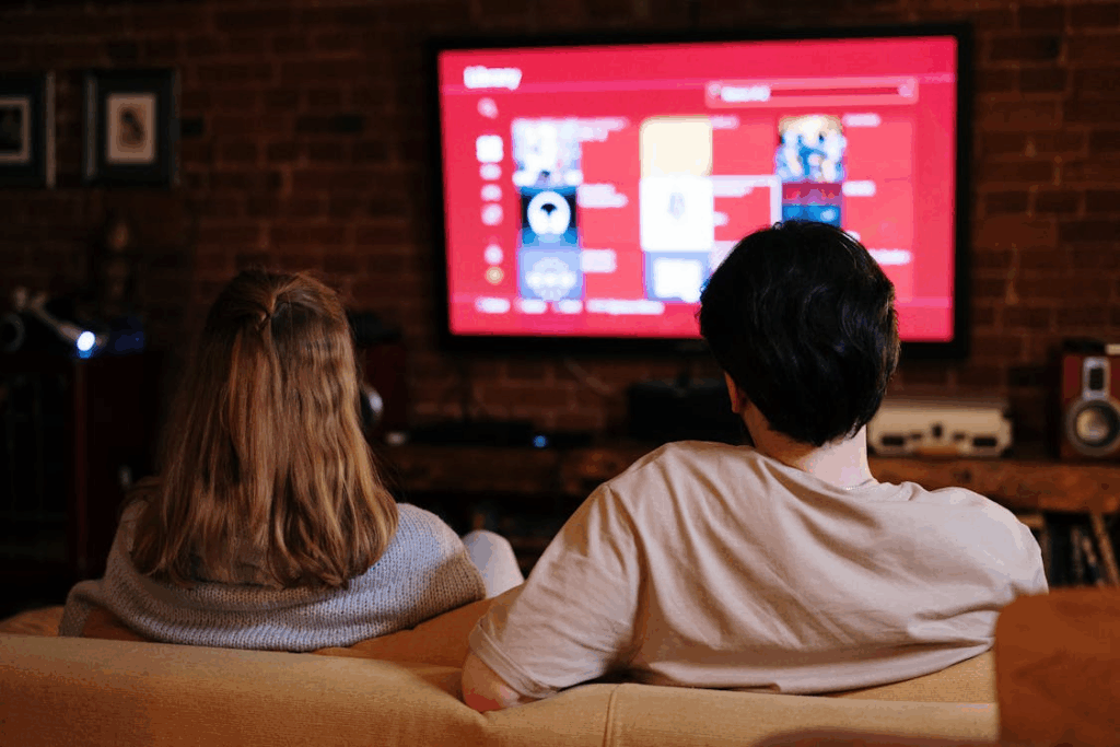 couple on couch watching streaming services which are seen to be a waste of money
