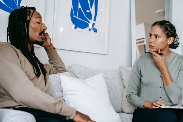 man and woman talking on a couch