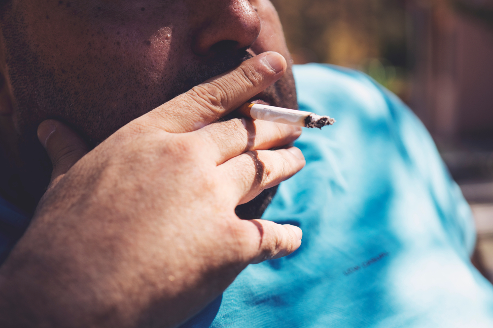 Fat man smoking cigarette outdoor close up