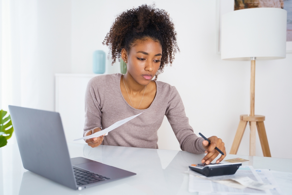 Woman holding paper bill, paying for gas, electricity and rent