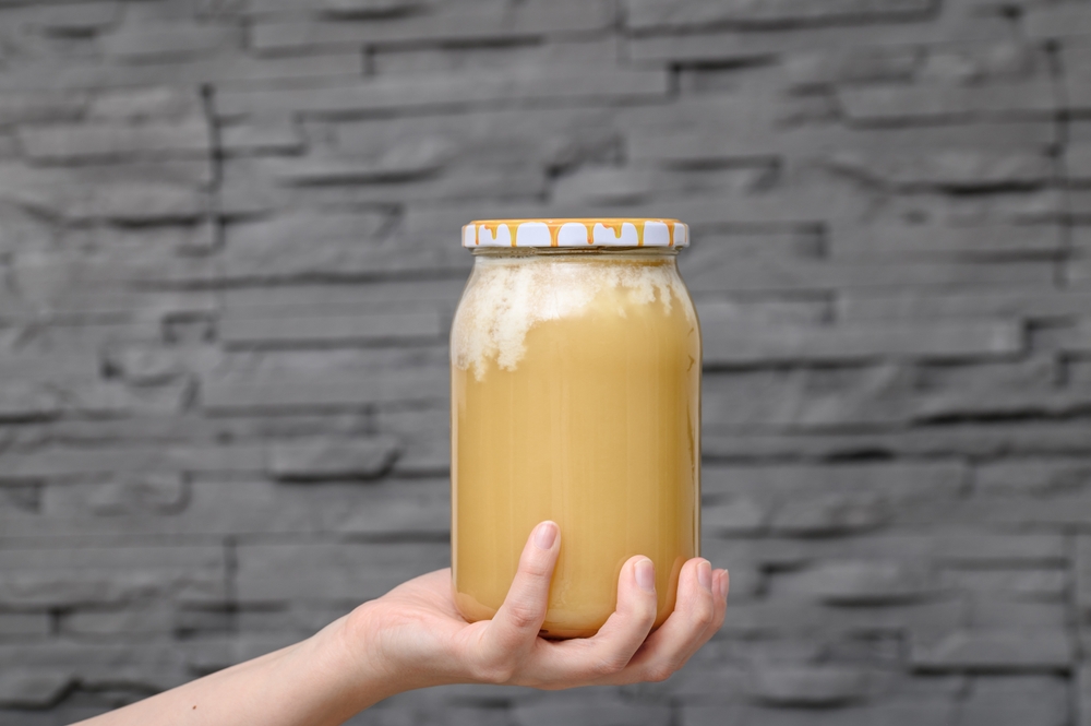 A jar of honey with a white coating of sediment, crystallization with a predominance of glucose
