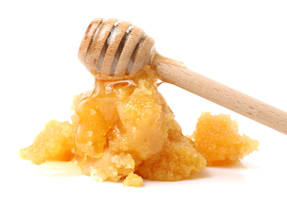 naturally crystallized rape honey on white wooden