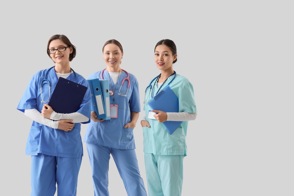 Female doctors with clipboards and folders on light background. International Nurses Day