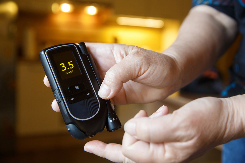 Hypoglycemic diabetic patient testing her blood for sugar level at home; low blood sugar. Medical process, self-diagnose, common metabolic, widespread and modern epidemic disease concept.
