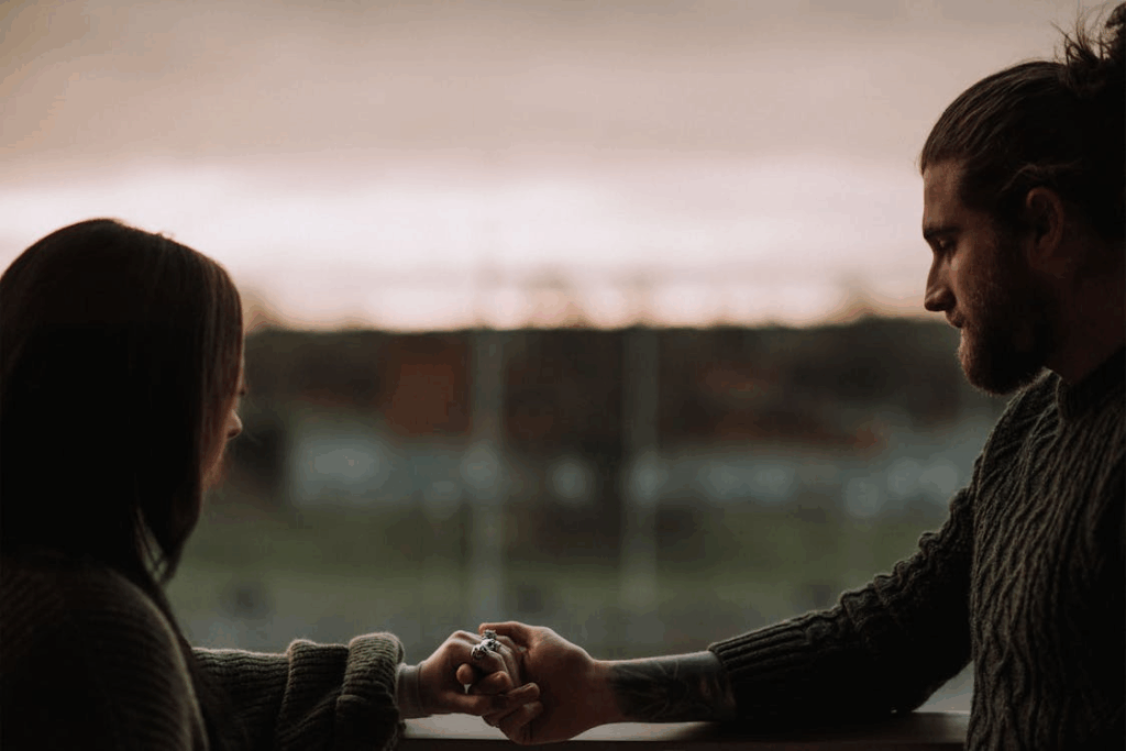 Two people comforting each other on a balcony.