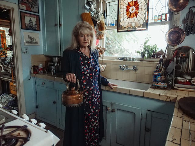 elderly woman in kitchen with kettle