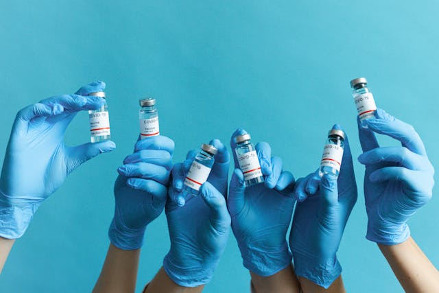 covid bottles held up by gloved hands