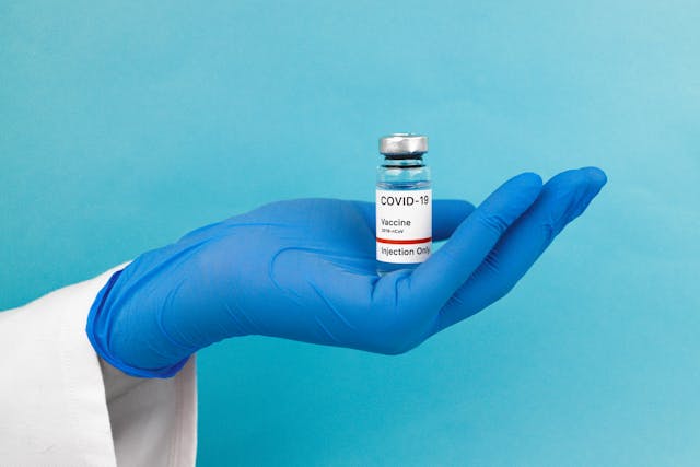 vaccine vial resting on gloved hand