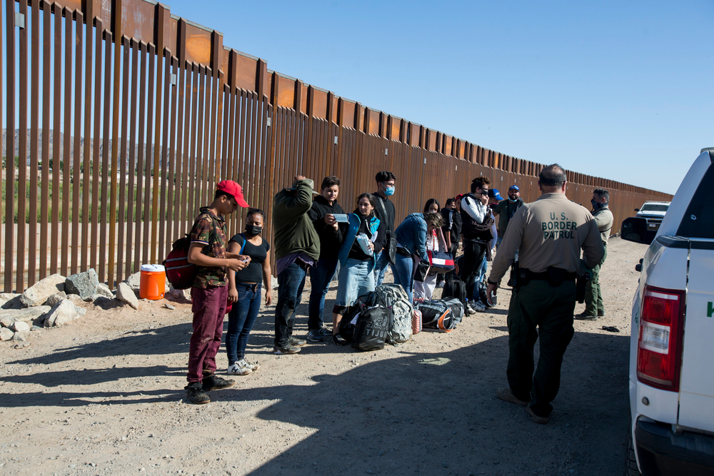 Migrants from Columbia wait to be processed after turning themselves over to authorities at the United States and Mexico border May 12, 2021 in Yuma, Arizona.