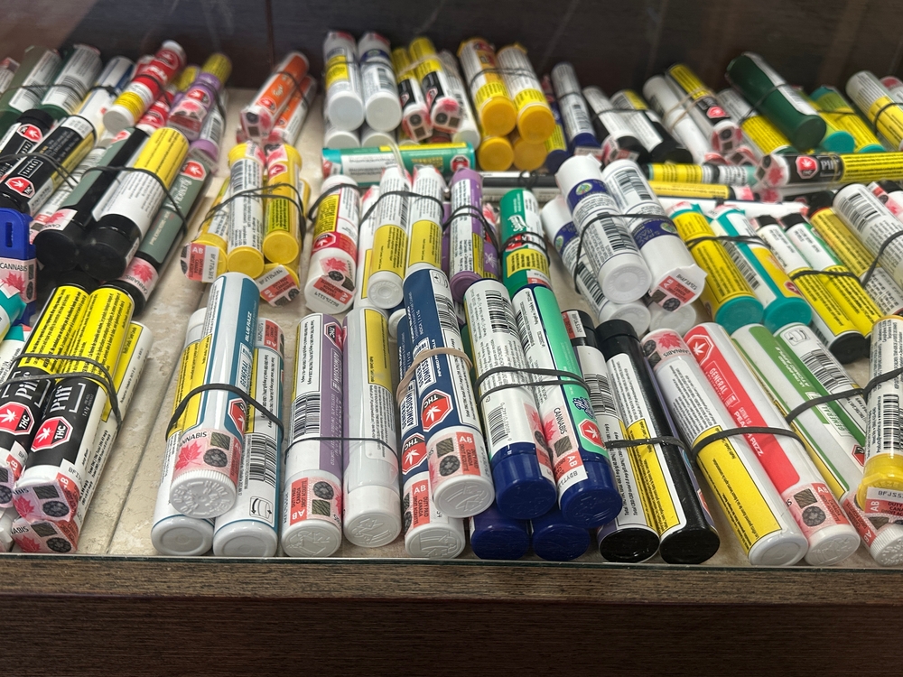 Cannabis Pre-Rolls with Warning Labels Displayed in Retail Storage Tray. Gleichen, Alberta, Canada. August 24 2025. For Editorial Use Only. This image represents the variety of legal cannabis products