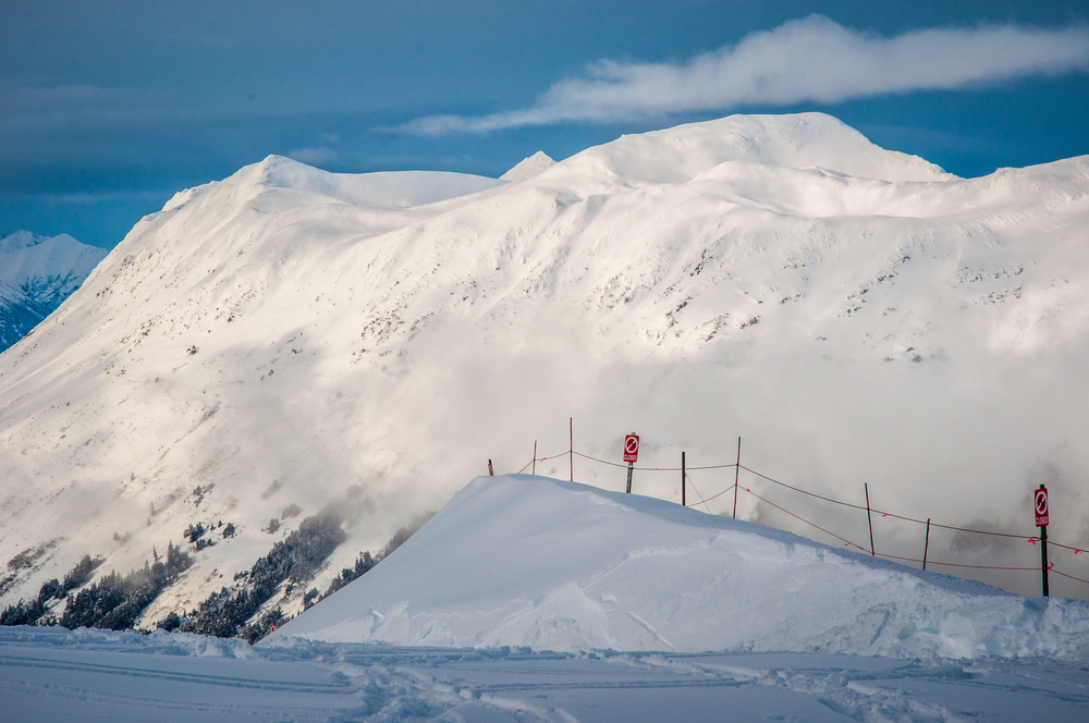 Alaska Snow Covered Mountains a Winter Wonderland Landscape View across Girdwood Valley looking at Steep Snow covered Face as the sun comes out and shines in the Arctic 