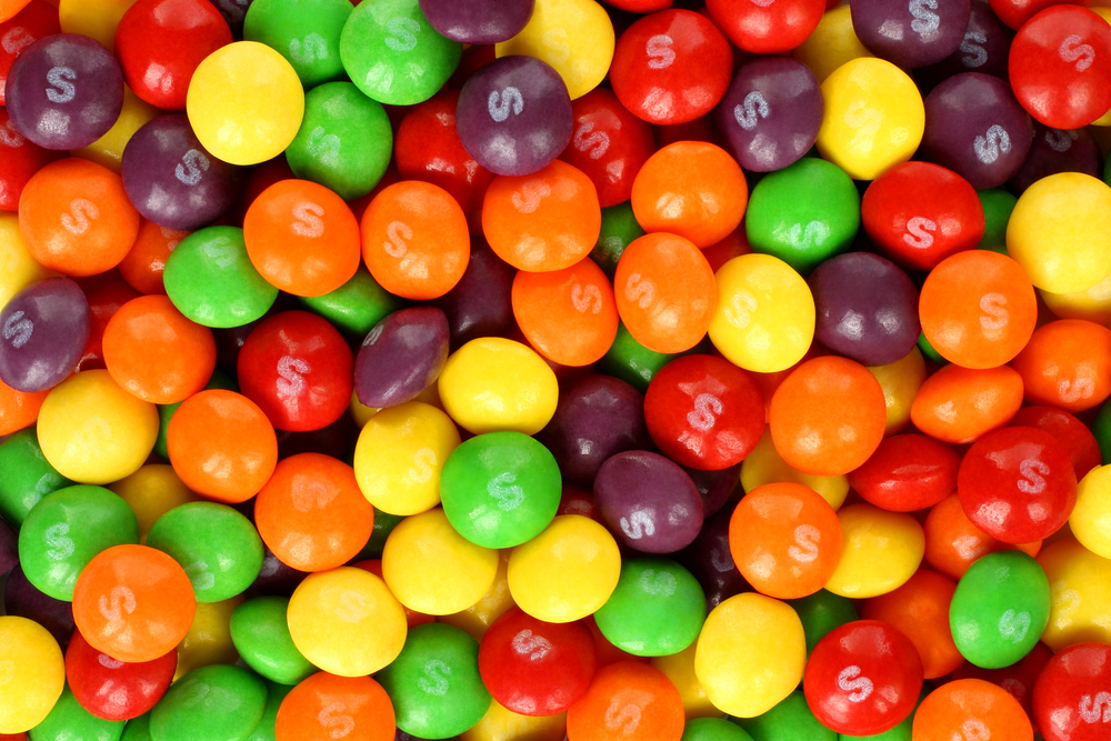 Kiev, Ukraine - September 22, 2017: Skittles multicolored fruit candies background. Skittles is a brand of fruit-flavoured.