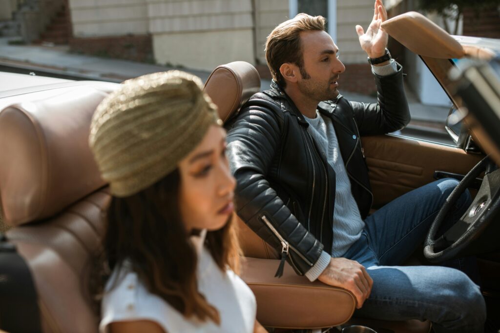 Man in Black Leather Jacket Sitting Beside Woman Having An Argument