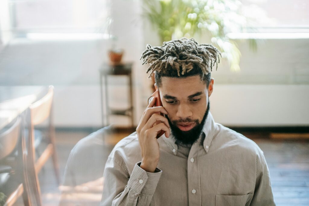 African American male talking on phone in office room