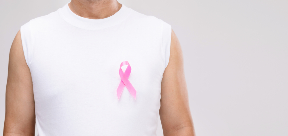 Breast cancer in men concept : Portrait Asian man and pink ribbon the symbol of breast cancer campaign. Studio shot isolated on grey background