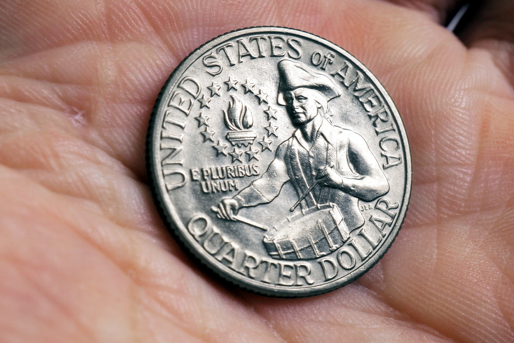 The USA quarter dollar coin with drummer lies in a palm close up. Illustration about American patriotism and Independence Day July 4. Macro