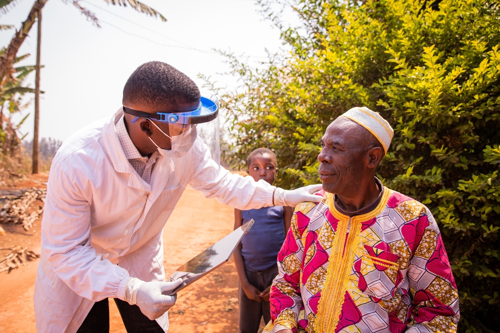 African doctor visits an elderly patient and they converse during the medical examination. Health care in africa concept