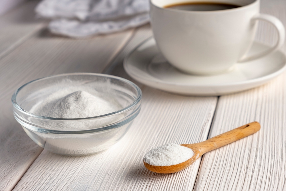 Herbal sweetener stevia in spoon and a cup of coffee.