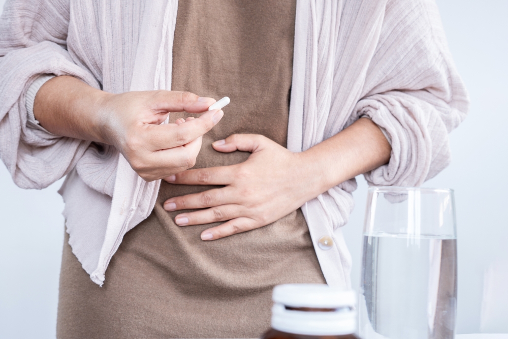  woman hand taking probiotic pill for diarrhea treatment 
