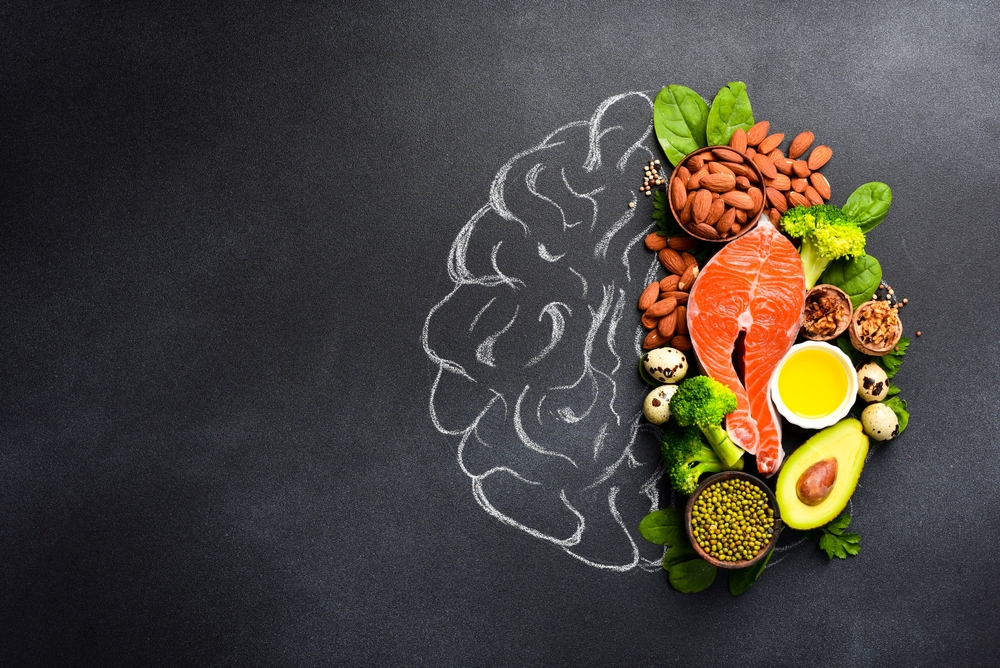 A picture of the brain drawn in chalk with various food products: fish, meat, nuts, vegetables and greens. Healthy food.