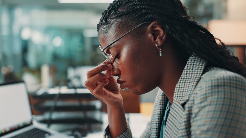 Professional, woman and headache of eye strain in office for article submission deadline, brain fog and burnout. Black person, journalist and migraine for incorrect prescription, fatigue and stress