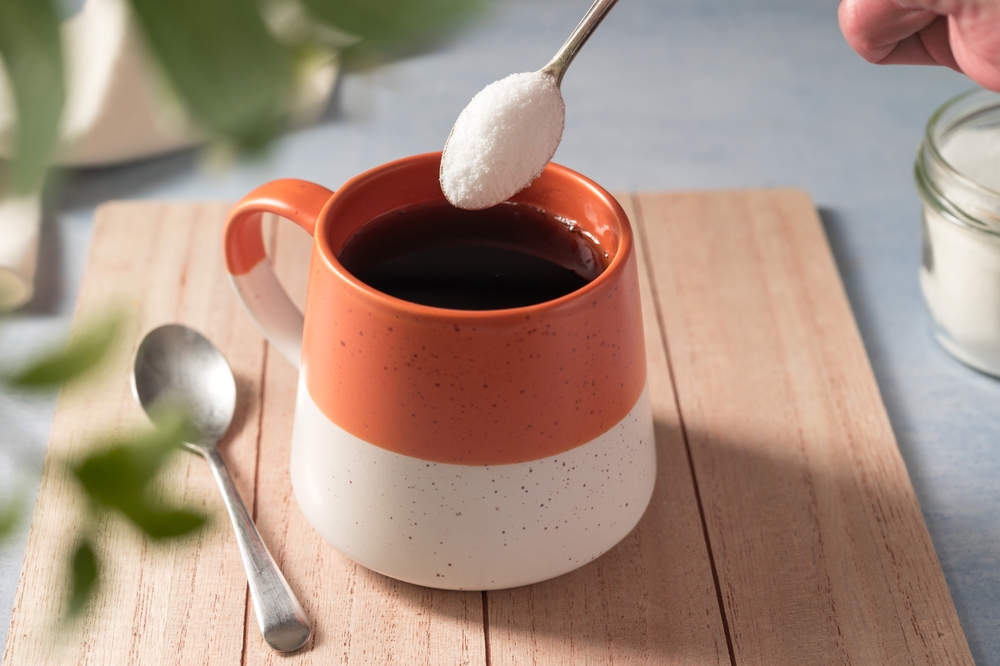 Pouring sweetener powder in cup of coffee. Sugar alternative, food and nutrition
