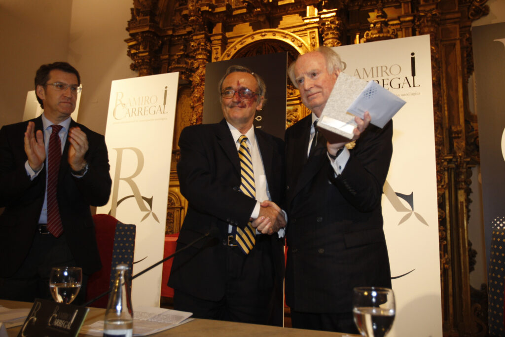 Mariano Barbacid, in the centre, receives the cancer research award sponsored by Ramiro Carregal, collecting it with his hands, an event also attended by the President of the Xunta of Galicia, Alberto Núñez Feijoo. Author: Certo Xornal
