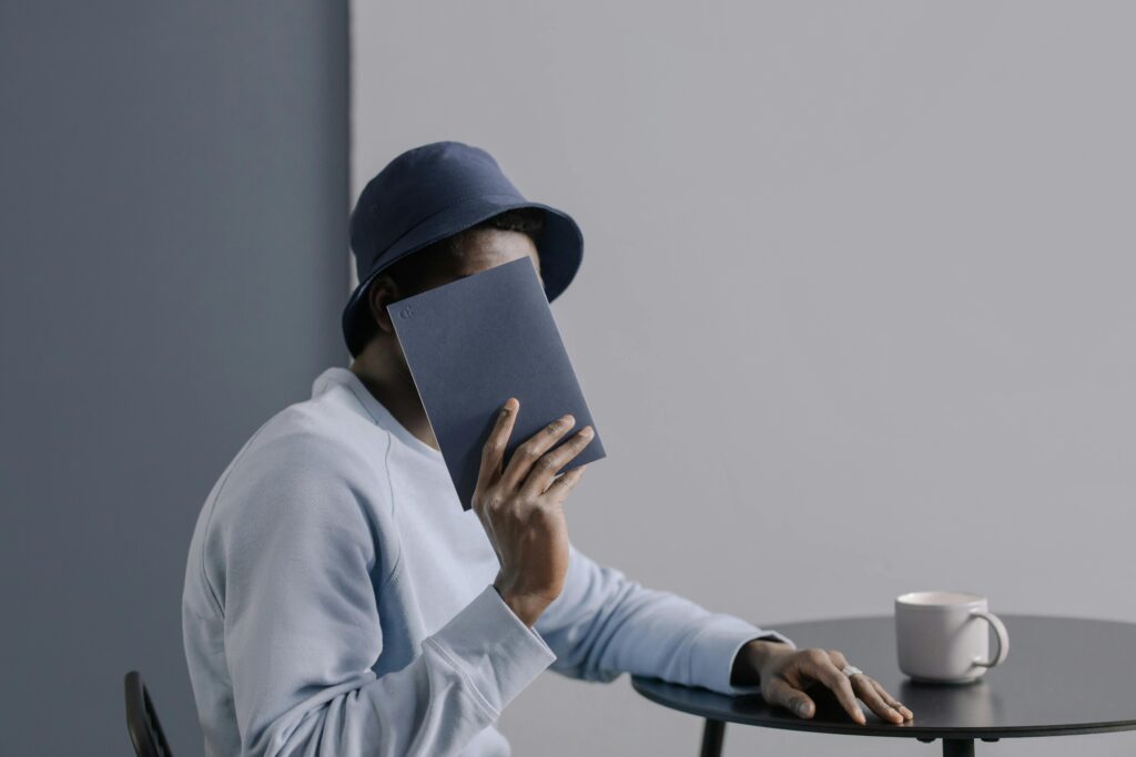 Man Holding a Notebook and Drinking Cup of Coffee