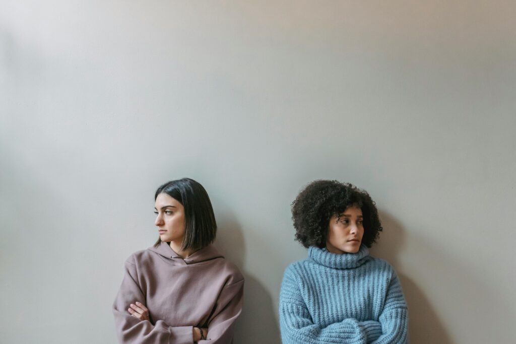 Upset diverse women near wall
