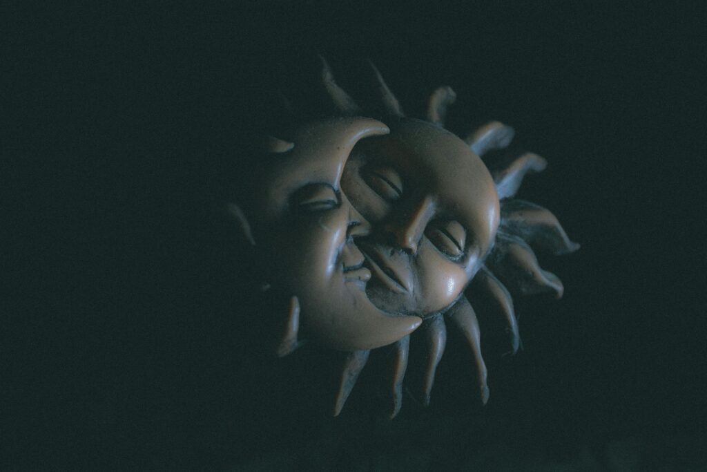 Embracing sun and moon faces made of clay