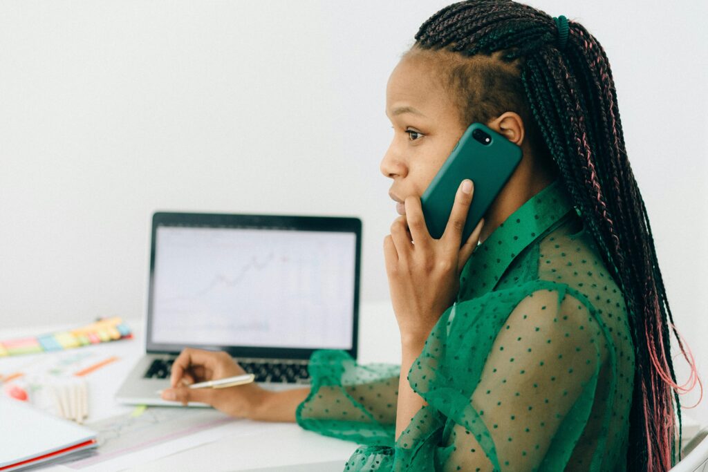 Woman in Green Long Sleeves Top Talking on the Phone