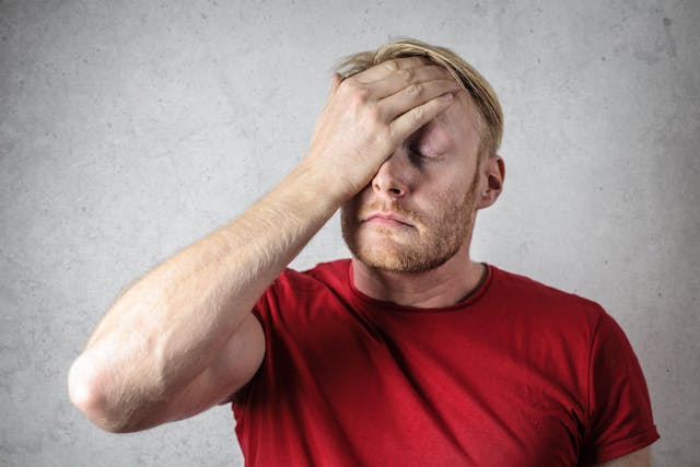 man holding head in pain