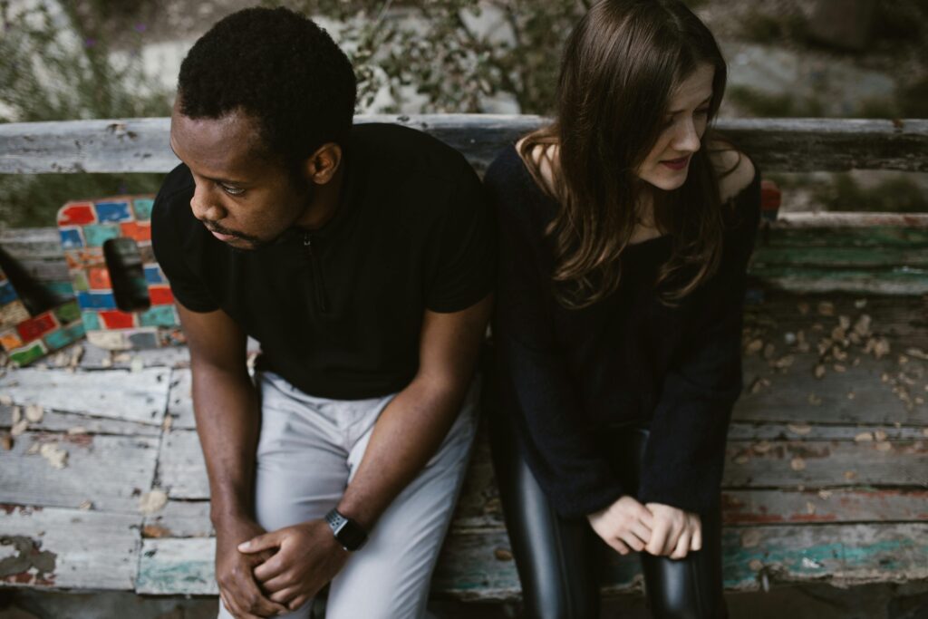 Upset Couple Sitting on Park Bench