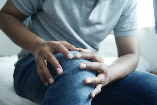 man holding knee in pain